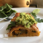 Butternut squash and spinach enchilada topped with guacamole